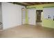 Unfinished basement with green walls, peg board, shelving, and doorway at 4020 Alligator Pt, Cumming, GA 30028