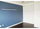 Minimalist bedroom with blue accent wall, modern lighting, hardwood floors, and white trim at 4020 Alligator Pt, Cumming, GA 30028