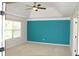 Bedroom featuring a ceiling fan, window and a teal accent wall at 4020 Alligator Pt, Cumming, GA 30028