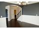 Spacious dining area with dark walls, wainscoting, hardwood floors, and an elegant chandelier at 4020 Alligator Pt, Cumming, GA 30028