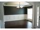 Elegant dining room with dark hardwood floors, wainscoting, and decorative chandelier at 4020 Alligator Pt, Cumming, GA 30028
