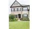 Charming two-story home with a brick facade, complemented by a well-manicured lawn and colorful flower beds at 4020 Alligator Pt, Cumming, GA 30028