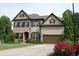 Beautiful two-story house with brick and siding, well-kept lawn, and colorful flowers at 4020 Alligator Pt, Cumming, GA 30028