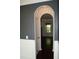 Hallway with hardwood floors, wainscoting, arched entryway, and neutral wall colors at 4020 Alligator Pt, Cumming, GA 30028