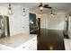 Open-concept living space with a kitchen island, stone fireplace, dark wood floors, and modern lighting at 4020 Alligator Pt, Cumming, GA 30028