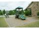 Community playground featuring a green playset with two slides and stairs, located next to a stone-accented building at 4020 Alligator Pt, Cumming, GA 30028