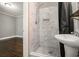 Bathroom with white marble shower, pebble floor and a pedestal sink at 4384 Herschel Rd, College Park, GA 30337