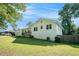 View of the house showing the side yard, painted brick, wooden fence, and mature shade trees at 4384 Herschel Rd, College Park, GA 30337
