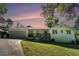 Charming white brick home featuring a covered front porch, attached garage and lush green lawn at 4384 Herschel Rd, College Park, GA 30337