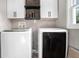 Laundry room featuring modern white cabinets, stylish hardware, and new front loading washer and dryer at 4384 Herschel Rd, College Park, GA 30337