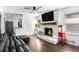 Cozy living room features a brick fireplace, hardwood floors, a ceiling fan and access to kitchen at 4384 Herschel Rd, College Park, GA 30337