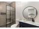 Modern bathroom featuring a glass-enclosed shower, stylish fixtures, and a vanity with a round mirror at 591 E Morningside Ne Dr, Atlanta, GA 30324