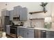 Modern kitchen with stainless steel appliances, gray cabinets, and open shelving at 591 E Morningside Ne Dr, Atlanta, GA 30324