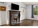 Elegant living room featuring a fireplace, hardwood floors, and natural light through a window with blue drapes at 591 E Morningside Ne Dr, Atlanta, GA 30324