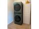 Laundry room with stacked washer/dryer and storage cabinet at 727 Channing Nw Dr, Atlanta, GA 30318