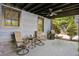 Covered back patio featuring a ceiling fan, outdoor seating, stone accents, and landscaping at 727 Channing Nw Dr, Atlanta, GA 30318