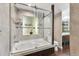 Bright bathroom features a tub, a window, a glass enclosure and stylish wallpaper at 130 26Th Nw St # 801, Atlanta, GA 30309
