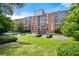 A charming brick apartment building with mature trees and green lawn, providing a tranquil setting at 130 26Th Nw St # 801, Atlanta, GA 30309