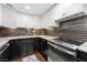 Well-equipped kitchen featuring black and white cabinets, subway backsplash, and stainless steel oven at 130 26Th Nw St # 801, Atlanta, GA 30309
