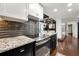 Modern kitchen with granite countertops, subway backsplash, stainless steel oven, and hardwood floors at 130 26Th Nw St # 801, Atlanta, GA 30309