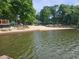 Lakefront area with sandy beach, kayak storage, and picnic tables, perfect for recreational activities at 2564 Wren Nw Ave, Duluth, GA 30096
