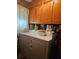 Functional laundry room with wooden cabinets and washer and dryer at 2564 Wren Nw Ave, Duluth, GA 30096