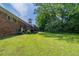 Green backyard with a brick home and wooden deck in the background at 29 Parkwood Ne Dr, Kennesaw, GA 30144