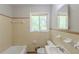 Standard bathroom features a bathtub, toilet, and sink, with a mirror and window providing natural light at 29 Parkwood Ne Dr, Kennesaw, GA 30144