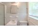 This is a bright bathroom with a shower, sink, toilet, and window with blinds at 29 Parkwood Ne Dr, Kennesaw, GA 30144