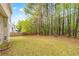 Large grassy backyard with views of trees, as well as a side view of the home at 642 Towering Pine Trl, Lawrenceville, GA 30045