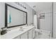 Bright bathroom features a large mirror, white vanity, and tiled shower with built-in shelving at 642 Towering Pine Trl, Lawrenceville, GA 30045