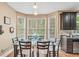 Bright breakfast nook with large windows and seating for six, adjacent to the kitchen at 642 Towering Pine Trl, Lawrenceville, GA 30045