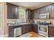 Cozy kitchen featuring stainless steel appliances, granite countertops, and dark wood cabinets at 642 Towering Pine Trl, Lawrenceville, GA 30045