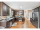 Spacious kitchen boasts stainless appliances, dark cabinets, granite counters, and hardwood floors at 642 Towering Pine Trl, Lawrenceville, GA 30045