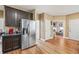 Open kitchen view with stainless steel refrigerator, dark wood cabinets, and hardwood floors at 642 Towering Pine Trl, Lawrenceville, GA 30045