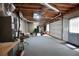 Spacious basement featuring an overhead door, painted concrete wall, and open rafter ceiling at 811 Ivy Ridge Dr, Loganville, GA 30052