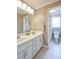 Bathroom with a double sink vanity, a tile floor, and a view into the adjacent tiled shower at 811 Ivy Ridge Dr, Loganville, GA 30052