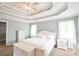 Calm bedroom with trey ceiling, soft blue walls, white bedding and bright, airy windows at 811 Ivy Ridge Dr, Loganville, GA 30052