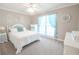 Bright bedroom with a large window and neutral walls, white furniture, and carpet flooring at 811 Ivy Ridge Dr, Loganville, GA 30052