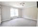 Spacious bedroom with a large window, white sheers, neutral walls, and gray carpet at 811 Ivy Ridge Dr, Loganville, GA 30052