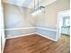 Elegant dining room featuring modern light fixture, wainscoting and hardwood floors, ideal for gatherings at 811 Ivy Ridge Dr, Loganville, GA 30052