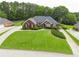 Charming brick home featuring lush green lawn, mature landscaping, and inviting entrance at 811 Ivy Ridge Dr, Loganville, GA 30052