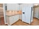 Bright kitchen features white cabinets, modern appliances, stone countertops, and a stylish tile backsplash at 811 Ivy Ridge Dr, Loganville, GA 30052
