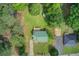Aerial view of a home with a green metal roof surrounded by mature trees and a sprawling green lawn at 173 Elder Dr, Social Circle, GA 30025