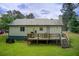 View of the backyard and a wooden deck with an outdoor dining area at 173 Elder Dr, Social Circle, GA 30025