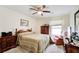 Comfortable bedroom featuring a ceiling fan, neutral walls, carpet flooring, and wooden furniture at 173 Elder Dr, Social Circle, GA 30025