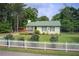 Charming home with a well-maintained lawn, picket fence, green metal roof, and inviting front porch at 173 Elder Dr, Social Circle, GA 30025