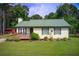 Charming one-story home featuring a green metal roof, inviting front deck, and lush lawn at 173 Elder Dr, Social Circle, GA 30025