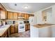 Charming kitchen featuring wooden cabinets, white appliances, and a tiled floor at 173 Elder Dr, Social Circle, GA 30025