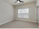 This carpeted bedroom features a ceiling fan and large window with custom blinds at 323 Concord St, Alpharetta, GA 30009